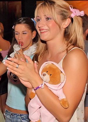 Teen blonde party girl with her teddy bear and lollipop and hair ribbons